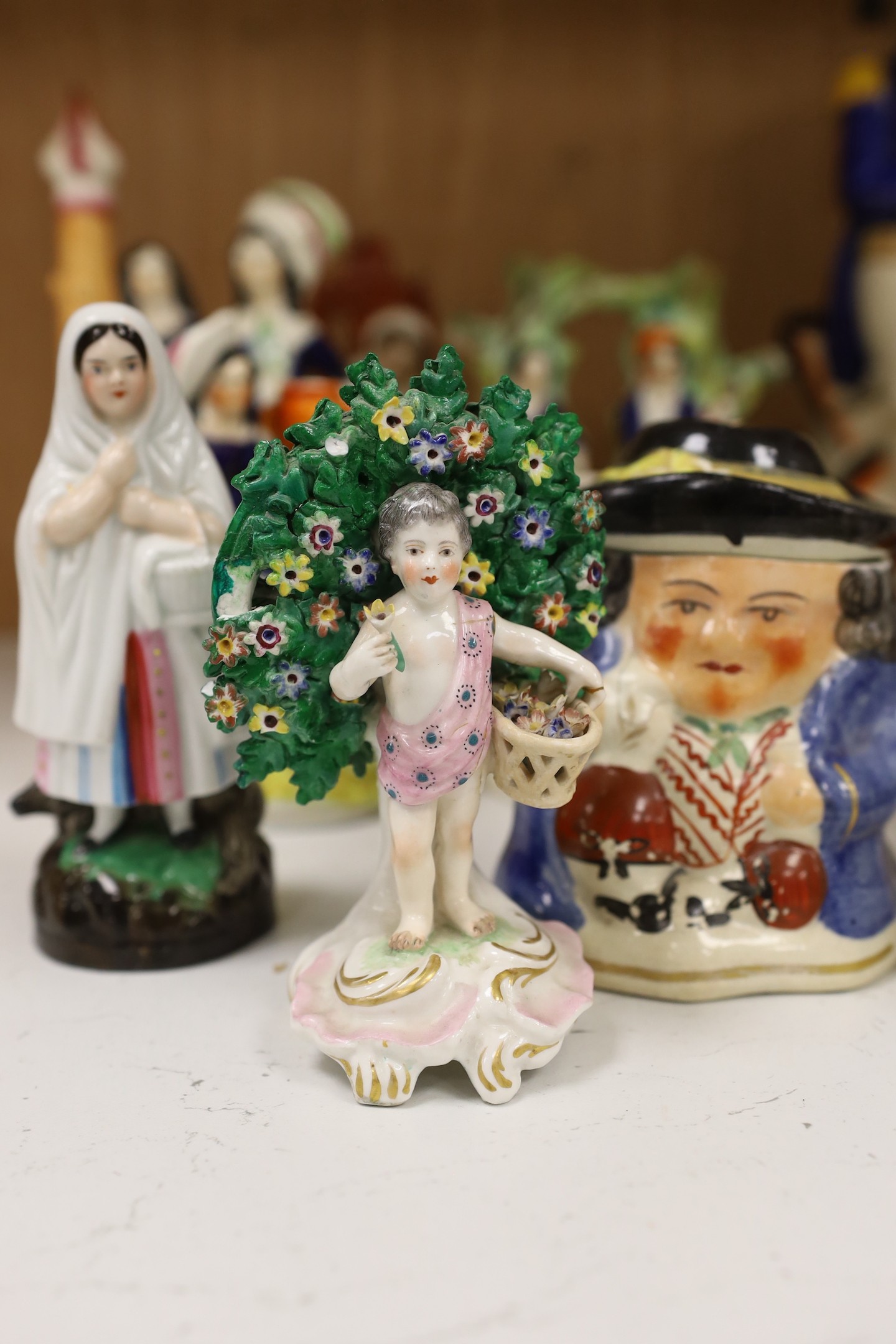 A large group of Staffordshire pottery figures and groups and figural cruets, to include a Nelson commemorative Toby jug, 31 cms high.